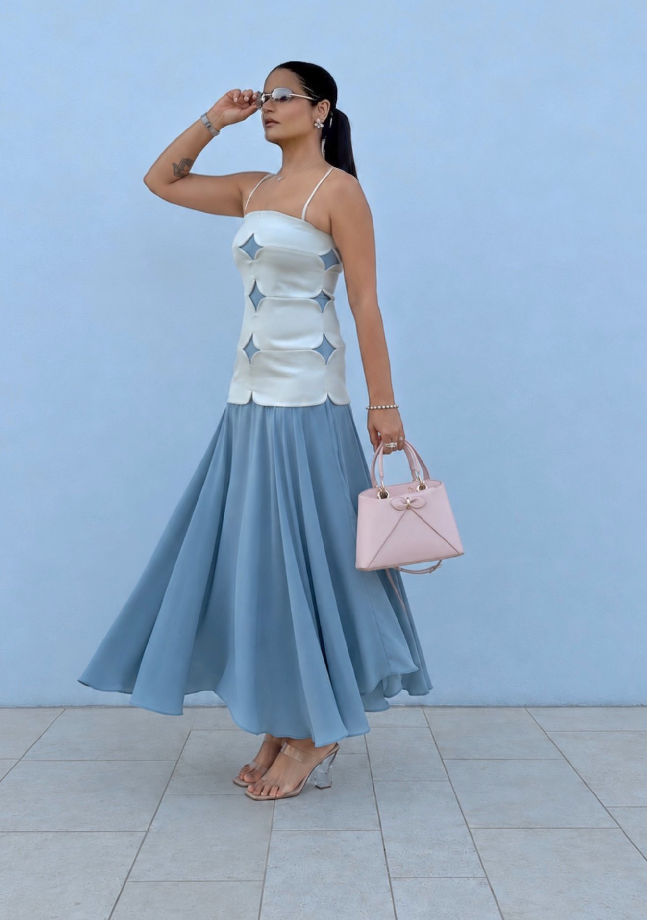 Aastha Chopra — powder blue satin cut-out dress with a blush mini bag, Dubai