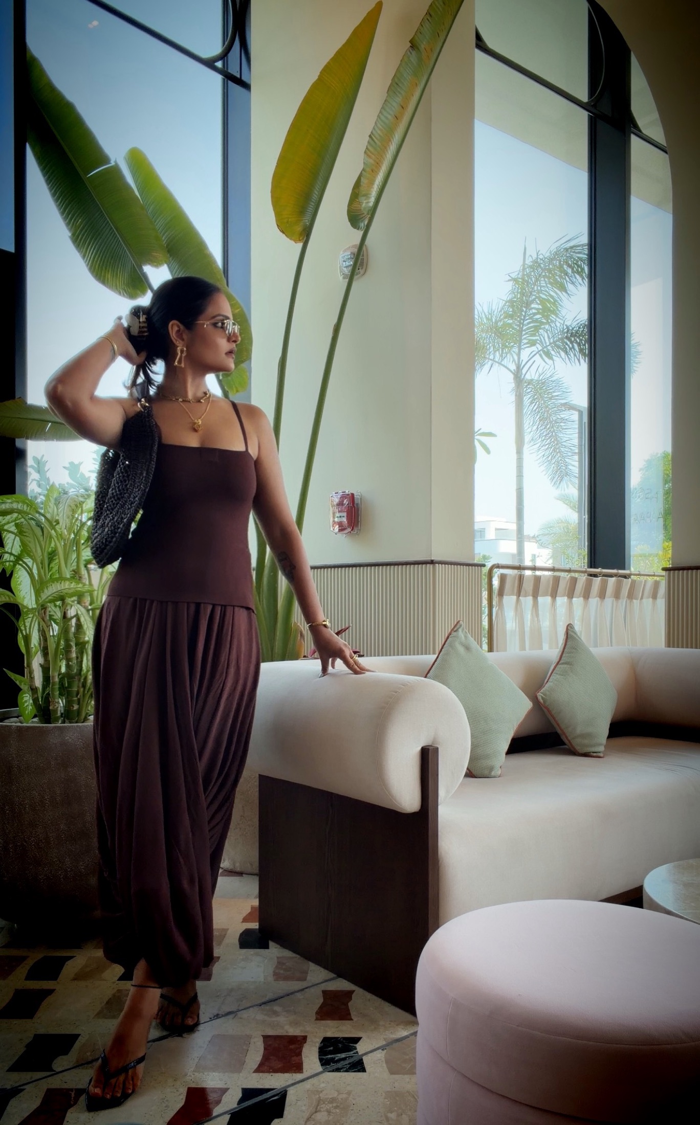 Aastha Chopra — chocolate brown draped look in a Dubai lounge